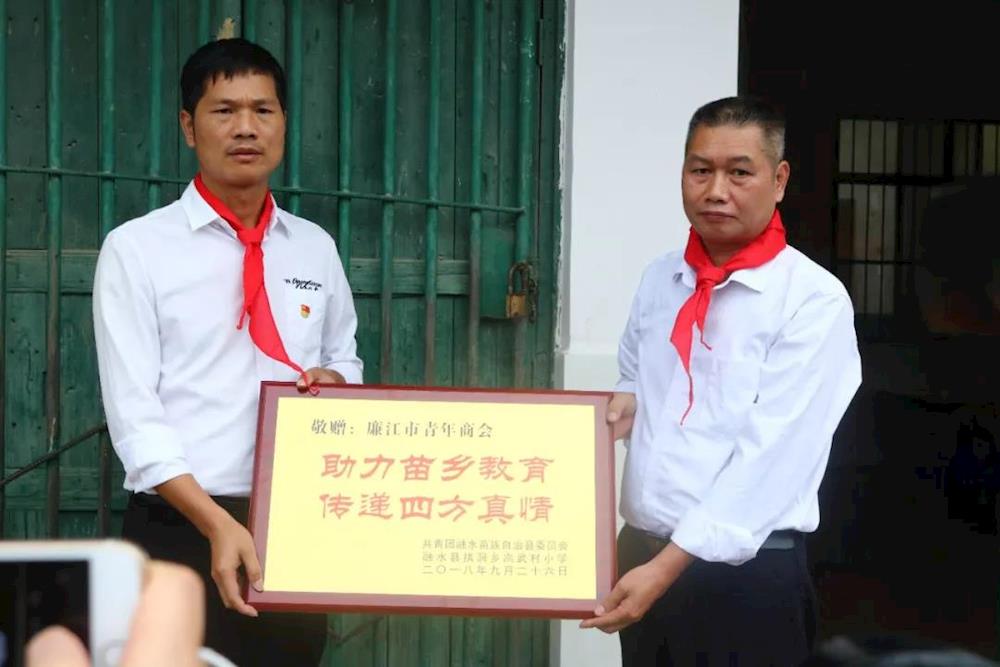 高武村小学校长向廉江市青商会代表张志位同志回赠牌匾